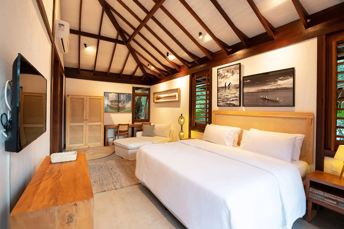 Suíte 3 com cama de casal, chaise e teto alto com vigas de madeira