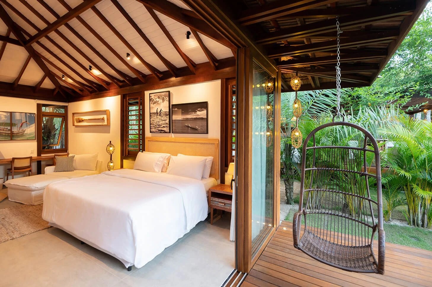 Quarto da Villa 2 com cama de casal e varanda com cadeira suspensa junto ao jardim