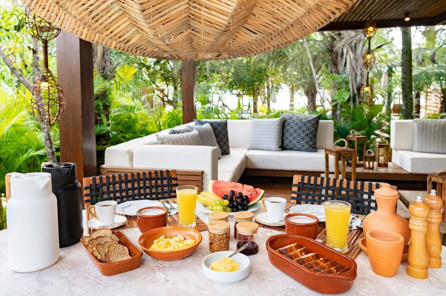 Mesa de café da manhã servida com frutas, pães e bebidas